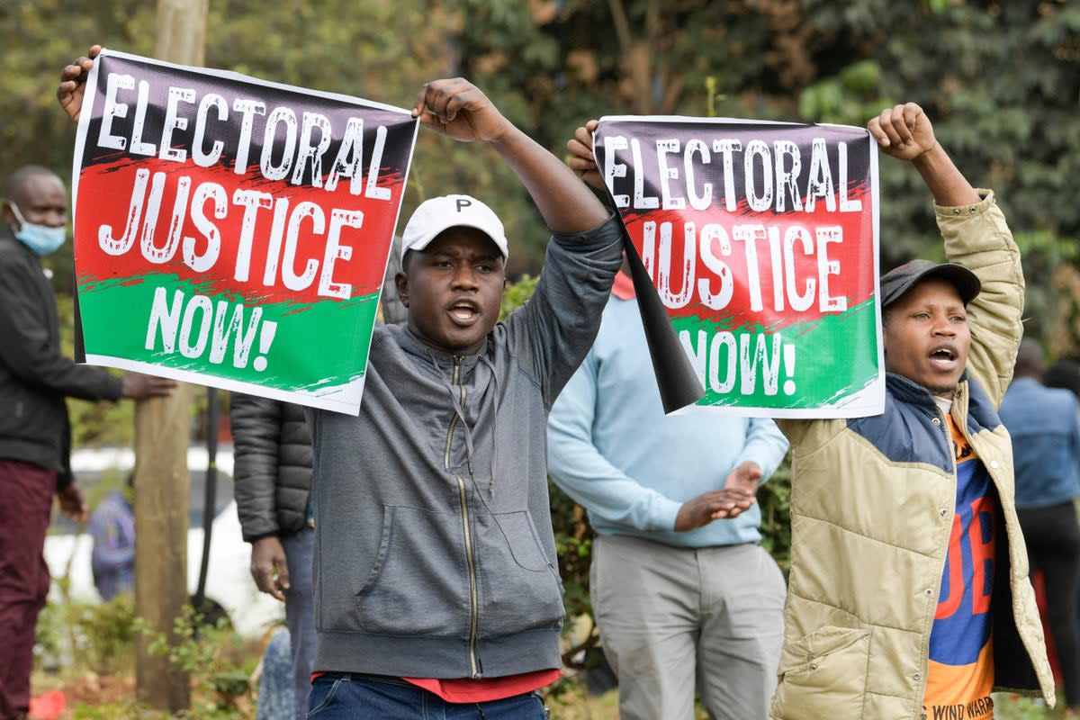Supporters of Raila Odinga sing as they gather outside the Milimani High Court in Nairobi  (AFP via Getty Images)