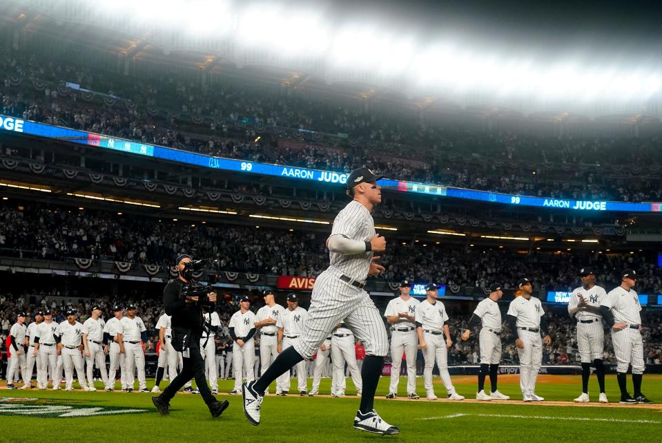 New York Yankees center fielder Aaron Judge (99) runs onto the field during player introductions before Game 1 of an American League Division baseball series against the Cleveland Guardians, Tuesday, Oct. 11, 2022, in New York. (AP Photo/Frank Franklin II)