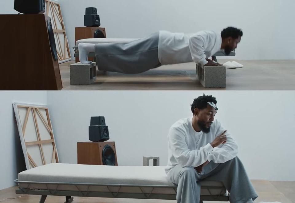 A screengrab of a scene in the "Not Like Us" music video. The top shows Kendrick Lamar doing pushups on cinderblocks in a white room, while the bottom shows him sitting on a bed in the same room.