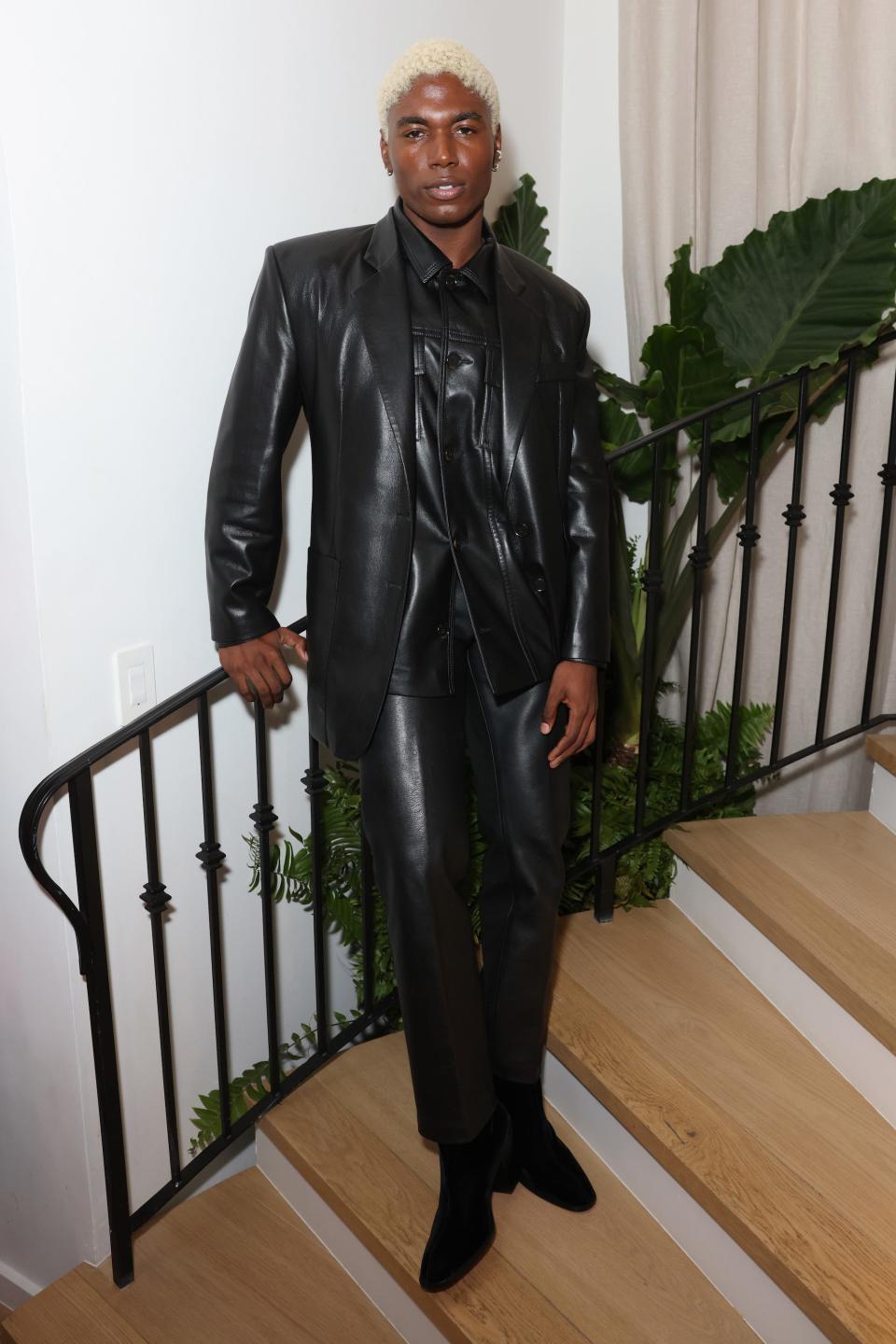 Deon Hinton poses in an all black, leather look on a pair of stairs.