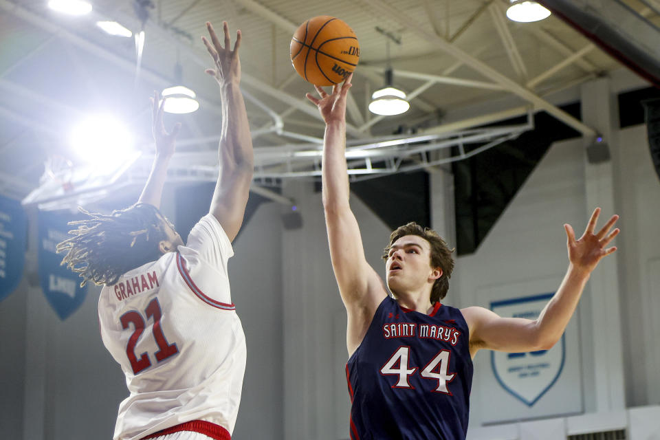 Saint Mary's guard Alex Ducas, right, shoots against Loyola Marymount forward Michael Graham during the first half of an NCAA college basketball game Thursday, Feb. 9, 2023, in Los Angeles. (AP Photo/Ringo H.W. Chiu)