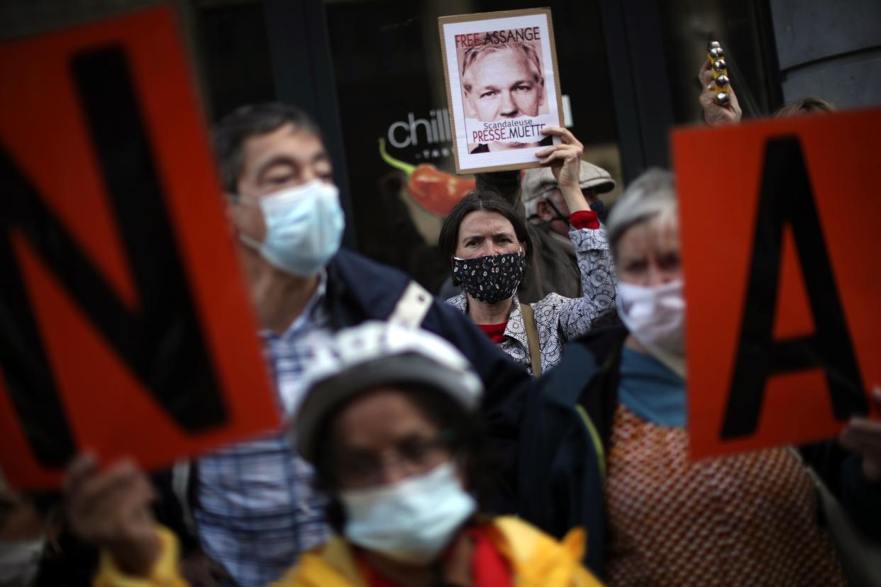 A woman holds up a photograph of WikiLeaks founder Julian Assange during a protest demanding the freedom of Assange in front of the UK embassy in Brussels, Belgium on Monday, Sept. 7, 2020.