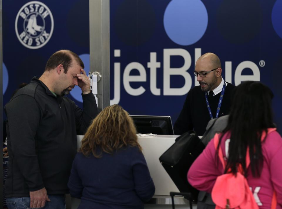 A traveler holds his forehead while waiting to rebook a cancelled JetBlue flight, Monday, Jan. 6, 2014, in Boston. JetBlue announced that they would halt operations in Boston, New York and New Jersey later in the afternoon, to rest their crews and give it time to service aircraft, due to flight delays and cancellations. Heavy rains in the East, and sub-zero temperatures in the Midwest, threw airlines and travel plans into havoc. (AP Photo/Charles Krupa)