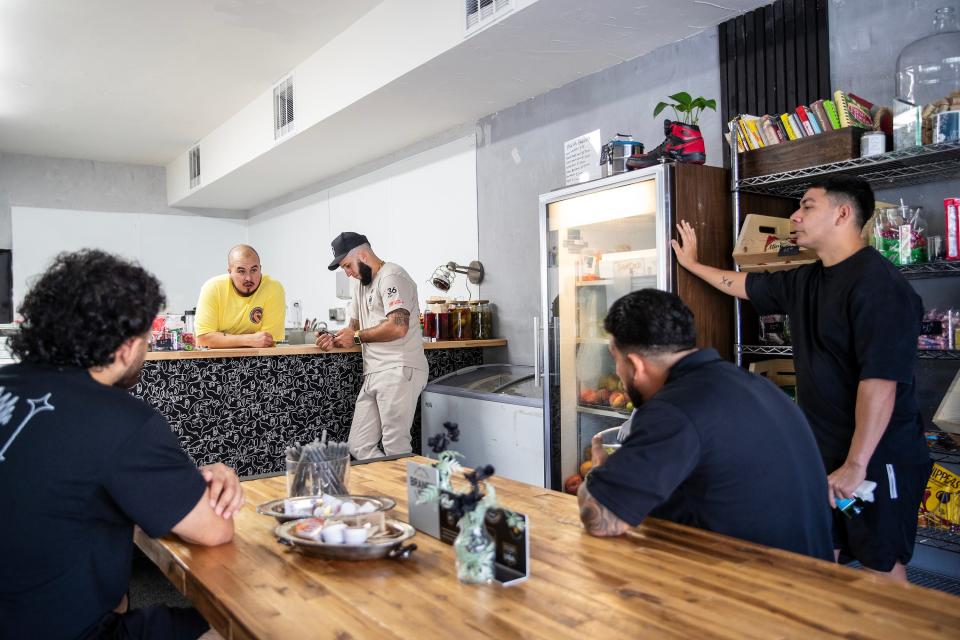 Lay' Vince owner and chef Jon Merchain, center, talks to staff from a neighboring business, Gentleman's Barbershop, as they finish their lunch at the restaurant in Palm Springs on Aug. 17.