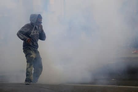 A man runs away from tear gas during clashes with French riot police at a march in Nantes, western France, to demonstrate against the new French labour law, September 15, 2016. REUTERS/Stephane Mahe