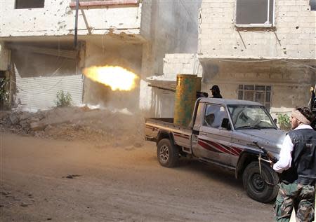 A rebel fighter fires during clashes with Syrian forces in eastern al-Ghouta, near Damascus April 8, 2014. Picture taken April 8, 2014. REUTERS/Ammar Al-Bushy