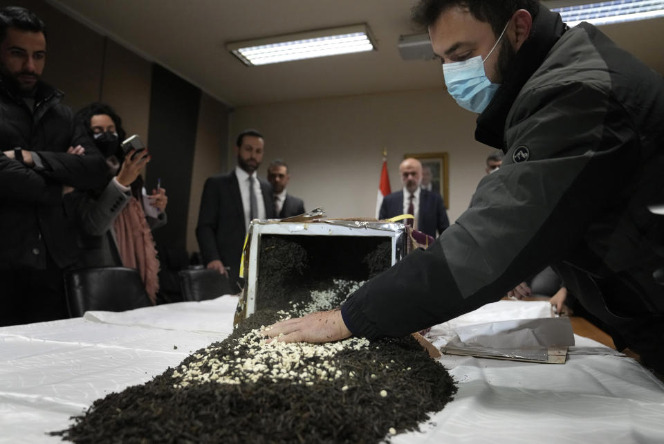 A security officer displays confiscated amphetamine Captagon pills which were hidden in 434 boxes mixed with seven tons of tea for export, at the Lebanese police headquarters, in Beirut, Lebanon, Tuesday, Jan. 25, 2022. Interior Minister Bassam Mawlawi said Lebanon's police intelligence thwarted the attempt to smuggle large amounts of Captagon that were on their way from Lebanon to the African nation of Togo to be sent from there to a Persian gulf nation, most likely Saudi Arabia. (AP Photo/Hussein Malla)