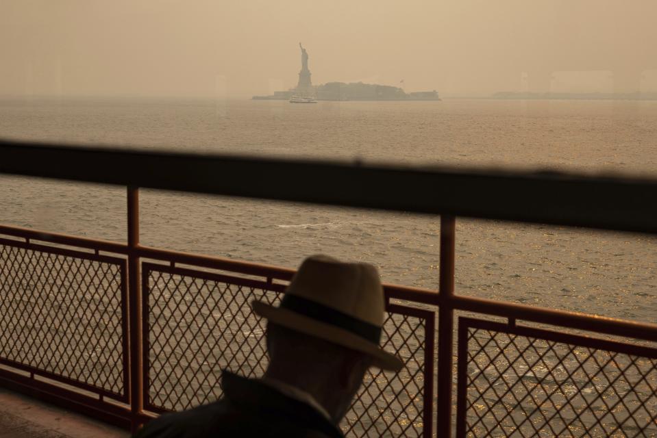 FILE - The Statue of Liberty, covered in a haze-filled sky, is photographed from the Staten Island Ferry, June 7, 2023, in New York. Thick, smoky air from Canadian wildfires made for days of misery in New York City and across the U.S. Northeast this week. But for much of the rest of the world, breathing dangerously polluted air is an inescapable fact of life — and death. (AP Photo/Yuki Iwamura, File)