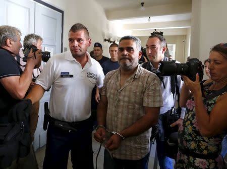 Police escort suspects in the deaths of 71 refugees found in a truck on an Austrian motorway, in Kecskemet, Hungary, August 29, 2015. REUTERS/Laszlo Balogh