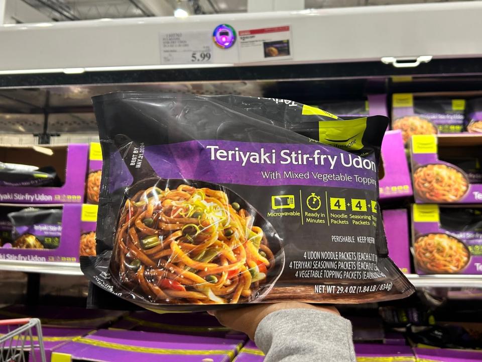 hand holding up a bag of frozen stir fry udon noodles at costco