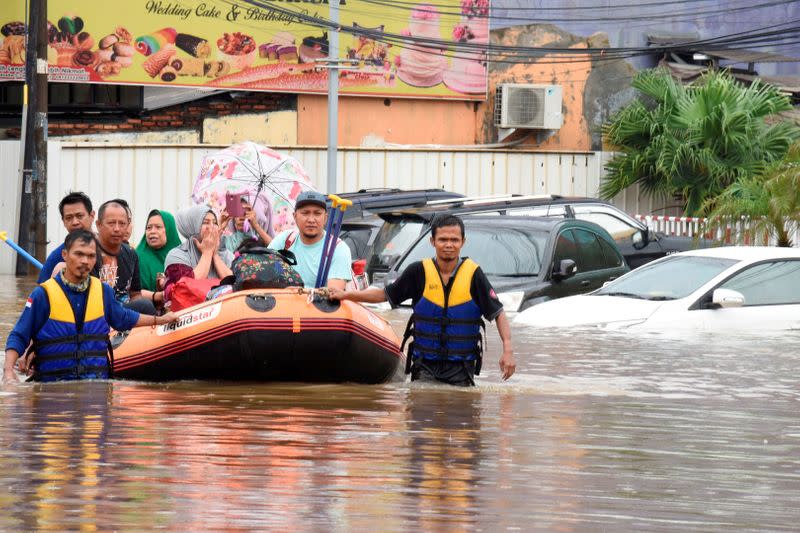 A rescue team evacuates locals on an inflatable boat during a flood after heavy rain in Bekasi, near Jakarta