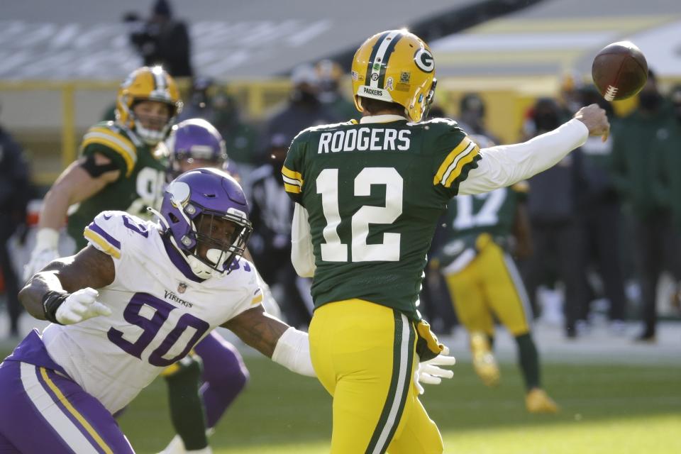 Green Bay Packers' Aaron Rodgers passes with Minnesota Vikings' Jalyn Holmes rushing during the second half of an NFL football game Sunday, Nov. 1, 2020, in Green Bay, Wis. (AP Photo/Mike Roemer)