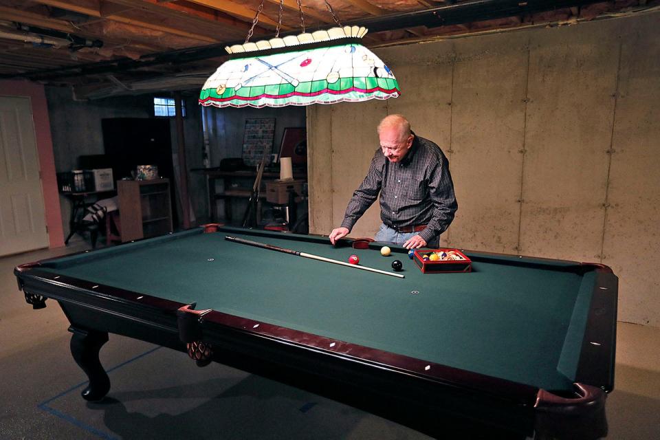 Larry Lavery with his his pool table in the basement of his new Weymouth home.