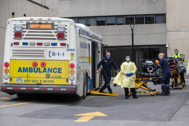 Paramedics at Kingston General Hospital in Kingston, Ont., after dropping off COVID-19 patients from the Greater Toronto Area on Thursday. (Lars Hagberg/Canadian Press - image credit)