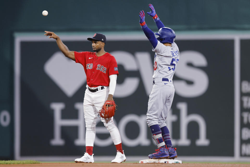 Los Angeles Dodgers' Mookie Betts (50) reacts next to Boston Red Sox second baseman Pablo Reyes after hitting a double during the sixth inning of a baseball game Friday, Aug. 25, 2023, in Boston. (AP Photo/Michael Dwyer)