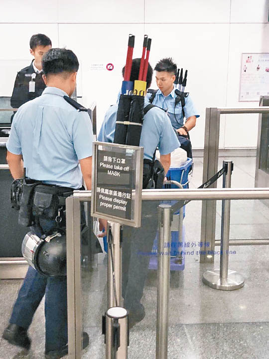手持旗袋的警員在機場禁區內戒備。（互聯網圖片）
