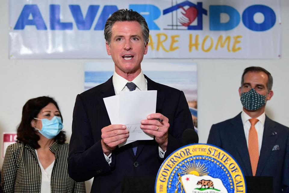 In this 2021 file photo, California Gov. Gavin Newsom displays seven bills he signed to address the homelessness crisis. Among his initiatives: Using Medicaid to pay for housing.