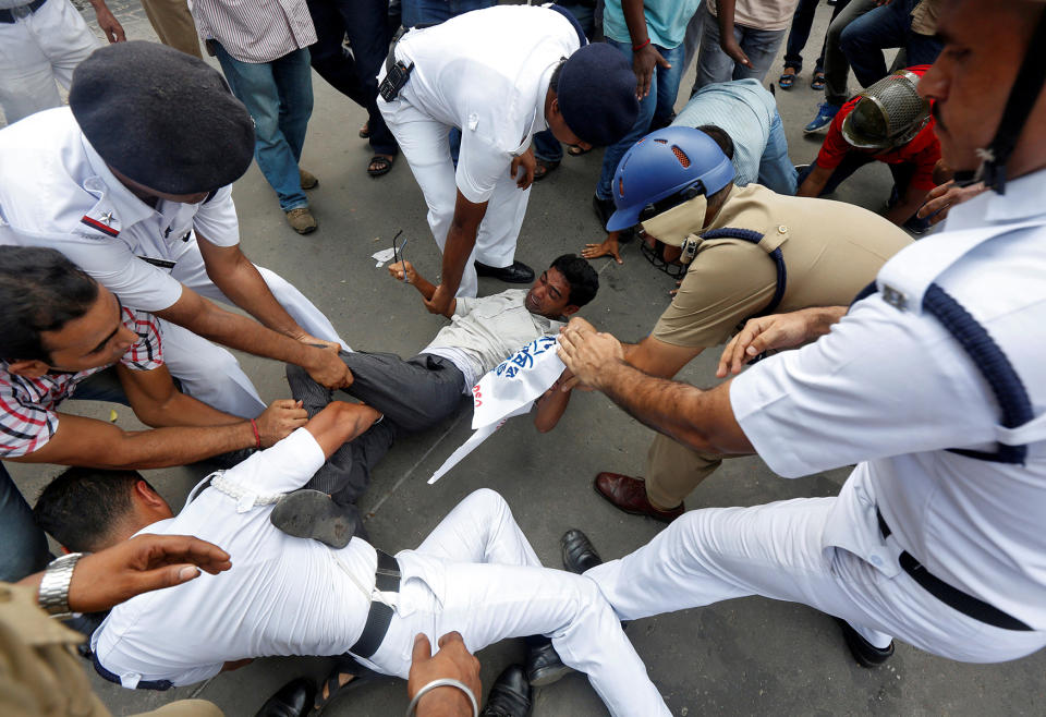 Police officers try to detain a demonstrator in Kolkata