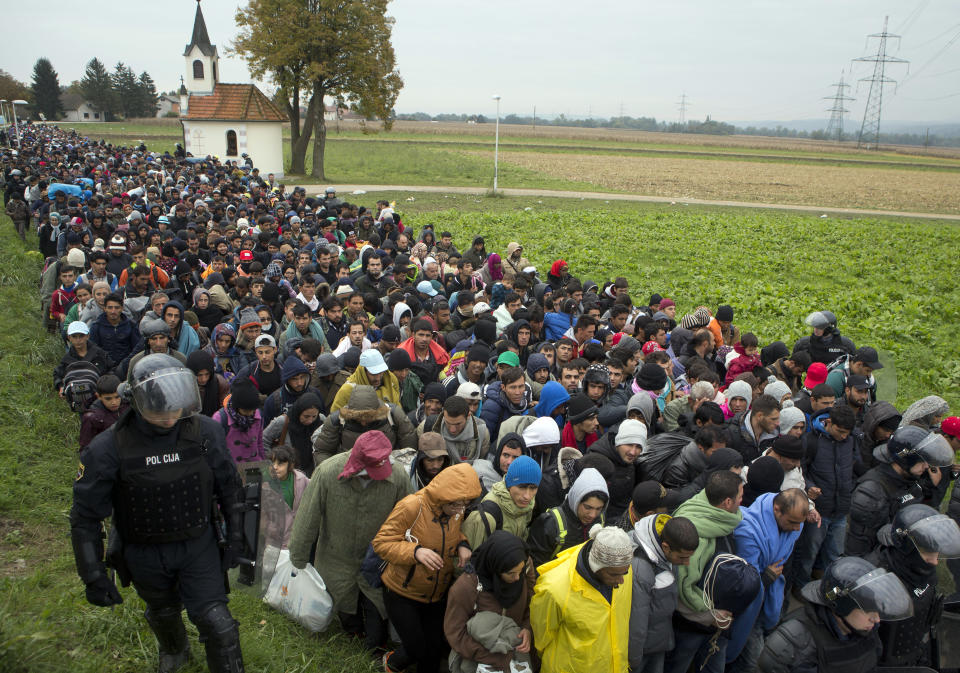 FILE - In this Thursday, Oct. 22, 2015 file photo migrants move past a chapel after crossing from Croatia, in Rigonce, near a border crossing between Croatia and Slovenia. Germany's conservative opposition leader Friedrich Merz said Tuesday that large-scale migration is one of the country's biggest problems and one of the main reasons for the recent surge in support for the far right. (AP Photo/Darko Bandic, file)