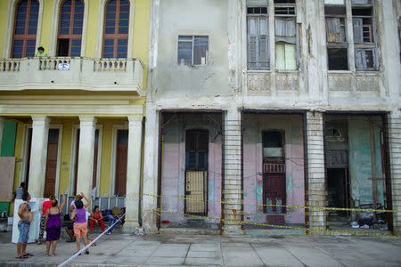 A family stay outside their home due to the risk of collapsing at the seafront Malecon after the passage of Hurricane Irma in Havana, Cuba, September 13, 2017. REUTERS/Alexandre Meneghini