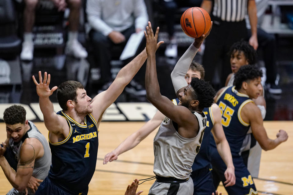 Purdue forward Trevion Williams (50) shoots over Michigan center Hunter Dickinson (1) during the second half of an NCAA college basketball game in West Lafayette, Ind., Friday, Jan. 22, 2021. (AP Photo/Michael Conroy)