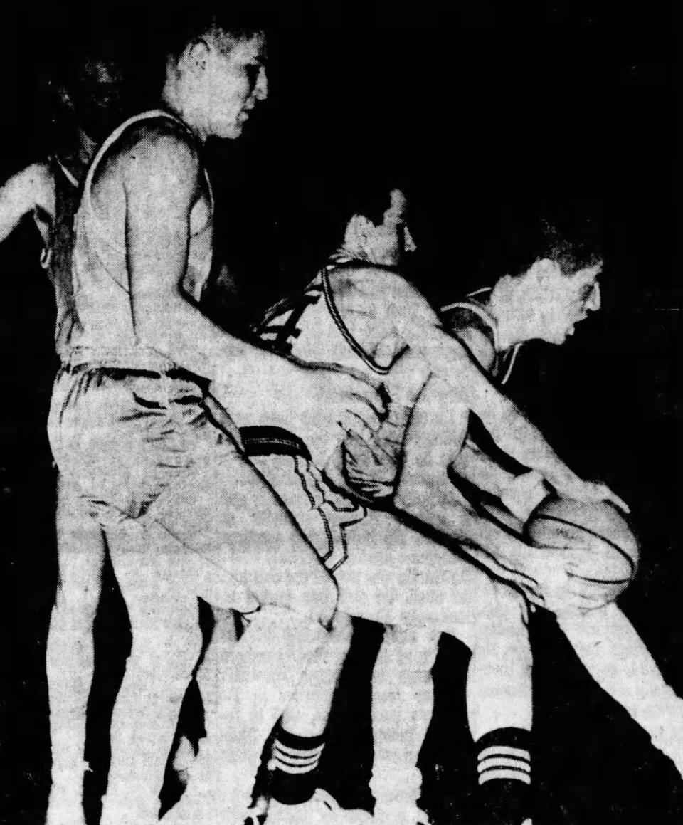 River Valley's Gary Tyo takes the ball, while teammates Harry Klingel and Dick Axline, background, converge on a Seven Mile player during a Class A regional semifinal game at Troy's Hobart Arena.
