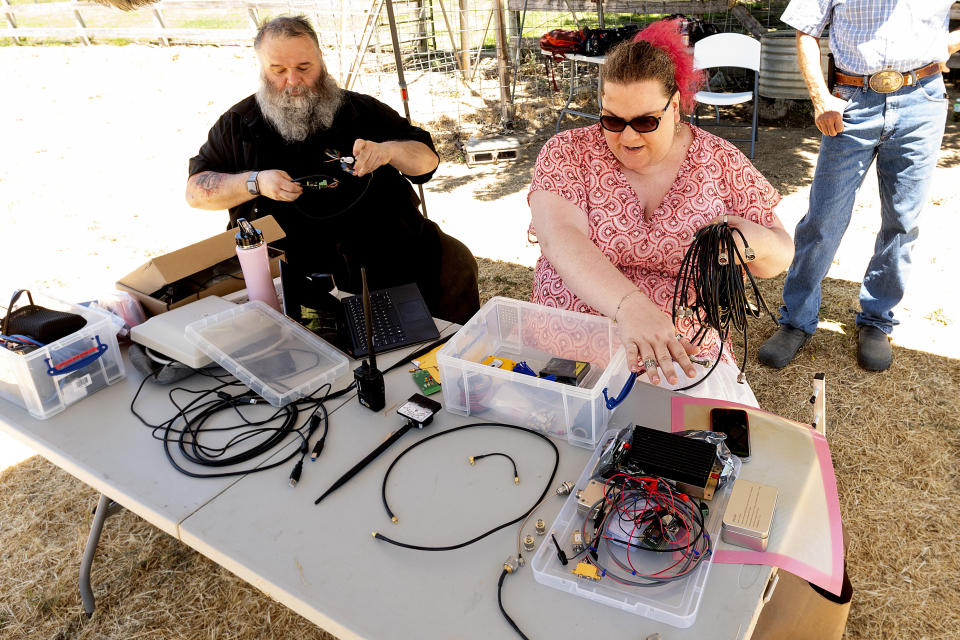 Hackers Kristin Paget, right, and Marc Rogers set up a test to measure radio frequency identification signal range in Hickman, Calif., on Sunday, June 6, 2021. Thin RFID tags embedded in military guns can trim hours off time-intensive tasks, such as weapon counts and distribution. Outside the armory, however, the same silent, invisible signals that help automate inventory checks could become an unwanted tracking beacon. (AP Photo/Noah Berger)