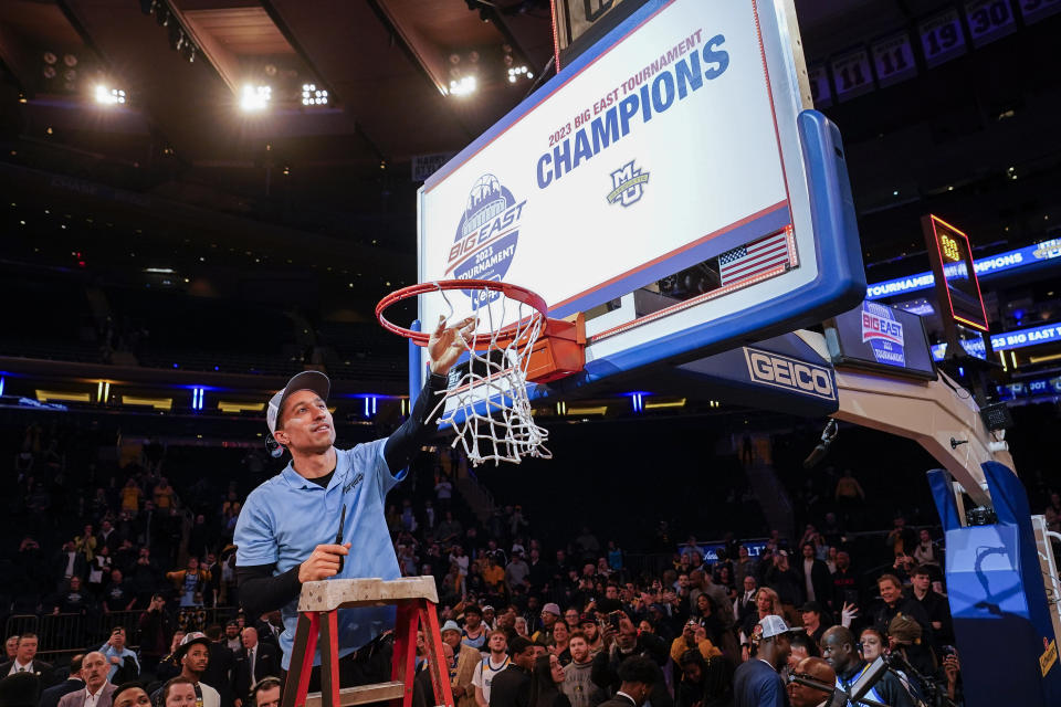 Marquette head coach Shaka Smart takes a piece of the net after winning their NCAA college basketball game against Xavier for the championship of the Big East men's tournament, Saturday, March 11, 2023, in New York. (AP Photo/John Minchillo)