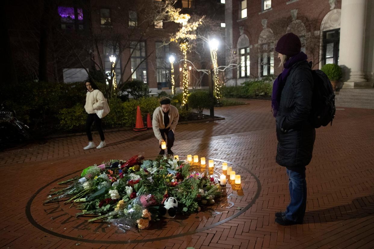 People pause and place a candle at a make-shift memorial for Tessa Majors inside the Barnard campus, Thursday, Dec. 12, 2019, in New York. Majors, a 18-year-old Barnard College freshman from Virginia, was fatally stabbed in a park near the school's campus in New York City.