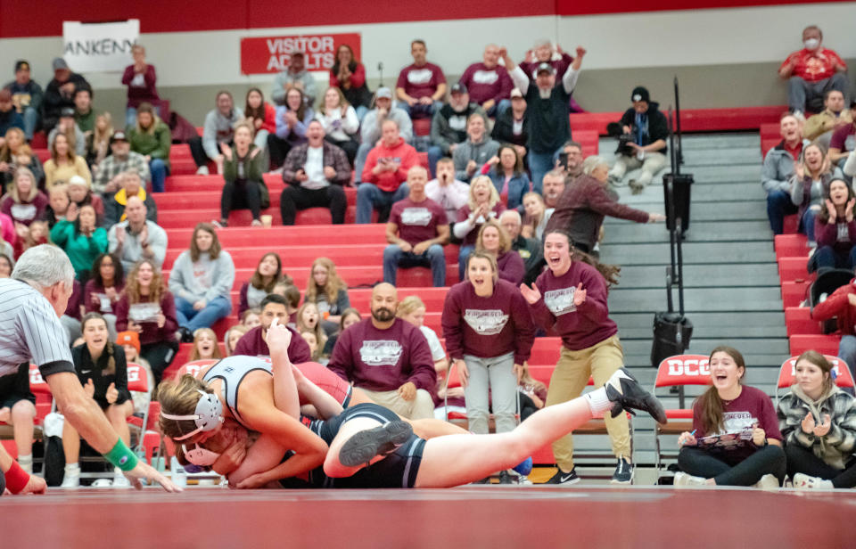 Dana Cleveland of Ankeny, top, battles Mackenzie Sizemore of Dallas Center-Grimes at 155 pounds during the first sanctioned girls wrestling dual in Iowa history Monday at Dallas Center-Grimes.