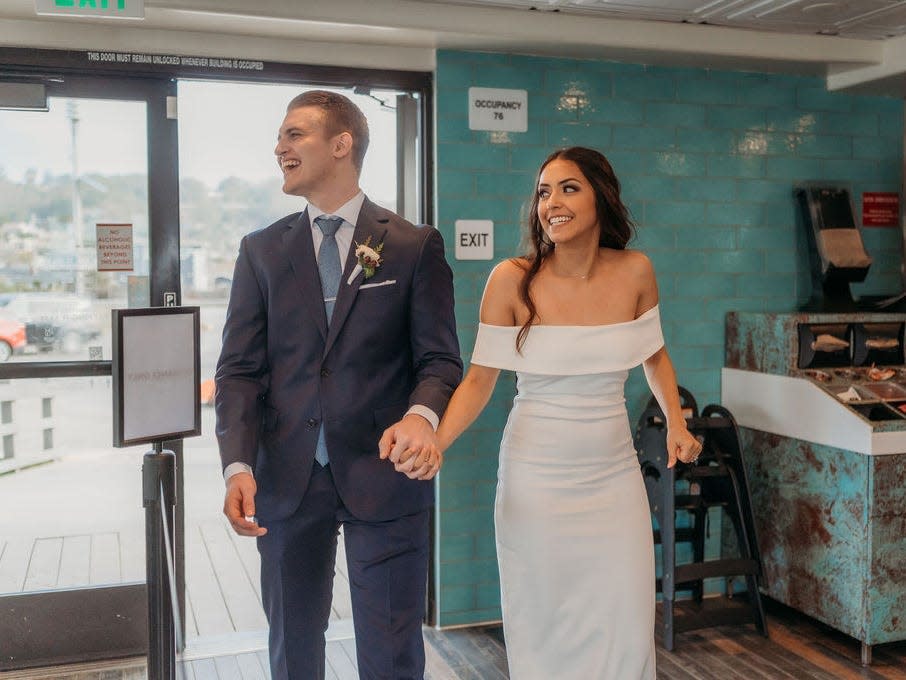 A couple walks into their wedding reception at Taco Bell Cantina.