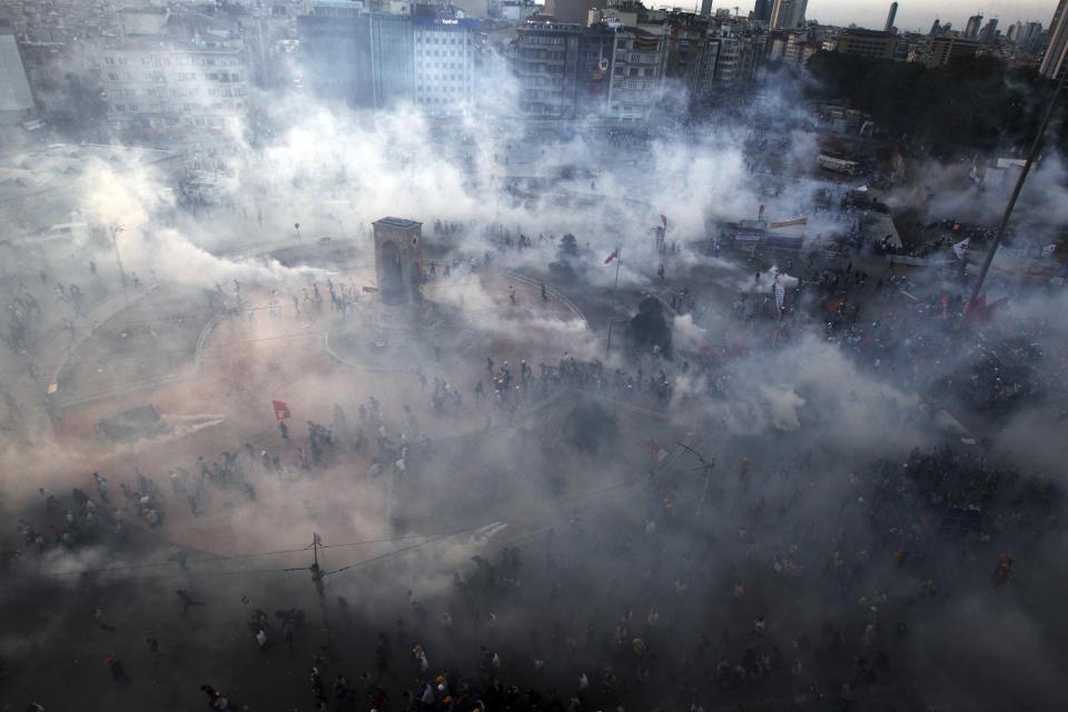 FILE - Protesters run to avoid tear gas during clashes at Taksim Square in Istanbul on June 11, 2013. (AP Photo/Thanassis Stavrakis, File)