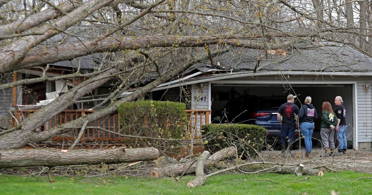 Amanda Schaffer, center left, inspects damage done to her house Thursday, April 18, 2024, after an EF-1 tornado struck Wednesday, April 17, 2024, in Windham.