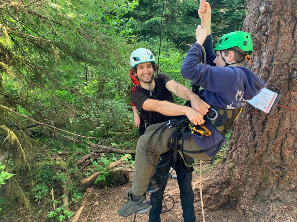 Leo Rosen-Fischer, owner of the outfitter Tree Climbing at Silver Falls, helps Til Diekotto, 11, of Eugene, get hit harness ready to climb up ropes coming down from trees at Silver Falls State Park in May.