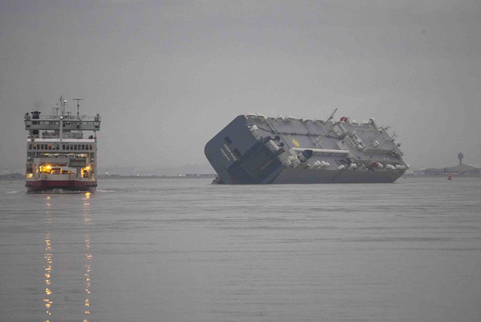 The cargo ship Hoegh Osaka lies on its side after being deliberately ran aground on the Bramble Bank in the Solent estuary near Southampton