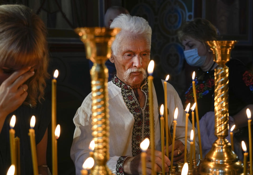 People light candles as they pray in the Mikhailovsky Zlatoverkhy Cathedral (St. Michael's Golden-Domed Cathedral) in Kyiv, Ukraine, Saturday, Aug. 21, 2021. Ecumenical Patriarch Bartholomew I, arrived to Kyiv to mark the 30th anniversary of Ukraine's independence that is celebrated on Aug. 24. (AP Photo/Efrem Lukatsky)