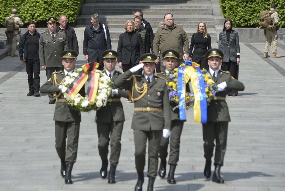 In this photo provided by the Ukrainian Parliament Press Office, Chairman of the Verkhovna Rada (Ukrainian parliament) Ruslan Stefanchuk, center right, and Barbel Bas, President of Bundestag, German parliament lay flowers at the monument of the Unknown Soldier at a memorial to World War II veterans in a memorial park in Kyiv, Ukraine, Sunday, May 8, 2022. (Ukrainian Parliament Press Office via AP)