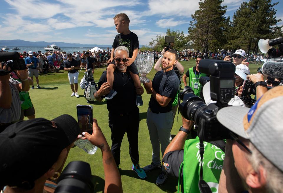Stephen Curry celebra con su padre Dell y su hijo Canon después de hundir el putt ganador durante la ronda final del torneo de golf American Century Celebrity Championship en el campo de golf Edgewood Tahoe en Stateline, Nevada, el domingo 16 de julio de 2023.