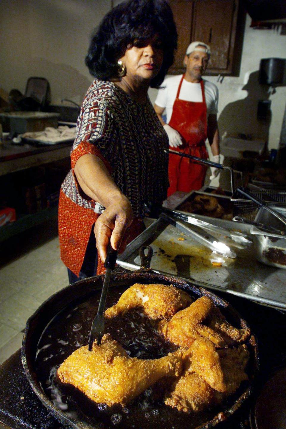 Andre Prince, owner of Prince's Hot Chicken Shack, fries up a batch of chicken in the kitchen alongside cook Larry Alexander in 2002.