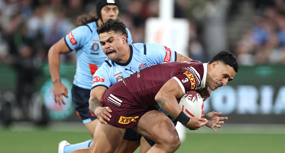 Seen here, Blues centre Latrell Mitchell tackles Maroons opposite Valentine Holmes in Origin Game 2. 