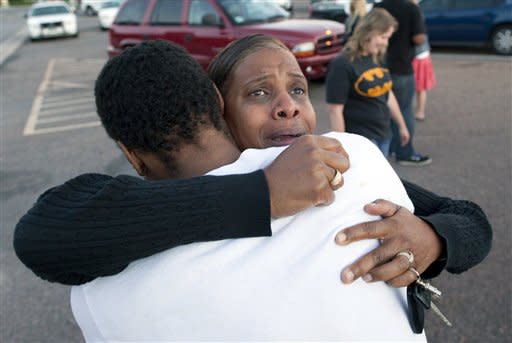 Shamecca Davis hugs her son Isaiah Bow, who was an eye witness to the shooting, outside Gateway High School where witness were brought for questioning Friday, July 20, 2012 in Denver. After leaving the theater Bow went back in to find his girlfriend. " I didn't want to leave her in there. But she's ok now," Bow said. A gunman wearing a gas mask set off an unknown gas and fired into a crowded movie theater at a midnight opening of the Batman movie "The Dark Knight Rises," killing at least 12 people and injuring at least 50 others, authorities said. (AP Photo/Barry Gutierrez)