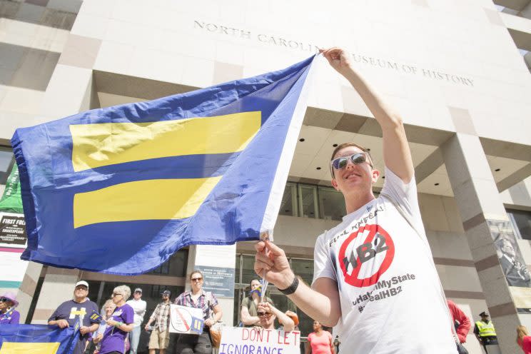 Trevor Chandler, associate regional field director for Human Rights Campaign, holds a flag during a Moral Monday rally calling for the repeal of House Bill 2 at the legislative building in Raleigh, NC Monday, April 25, 2016. (Photo: Jason E. Miczek/AP Images for Human Rights Campaign)