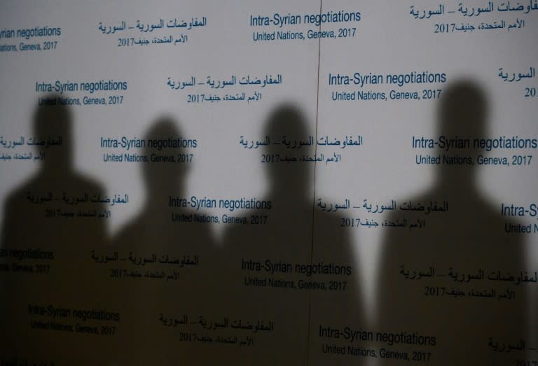 Shadows of members of Syria's main opposition High Negotiations Committee are casted on a backdrop during a press conference on Syria peace talks on February 27, 2017, in Geneva