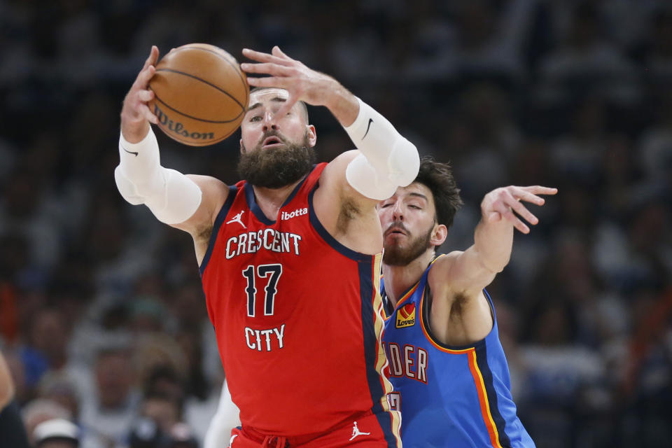 New Orleans Pelicans center Jonas Valanciunas (17) grabs the ball in front of Oklahoma City Thunder forward Chet Holmgren, back, during the first half in Game 2 of an NBA basketball first-round playoff series, Wednesday, April 24, 2024, in Oklahoma City. (AP Photo/Nate Billings)