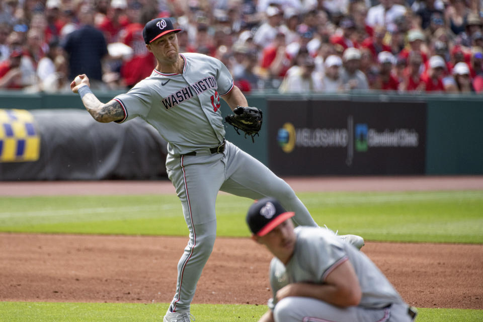 Washington Nationals' Nick Senzel throws to first base but not in time to get Cleveland Guardians' Jose Ramirez out as Mitchell Parker ducks during the first inning of a baseball game in Cleveland, Saturday, June 1, 2024. (AP Photo/Phil Long)