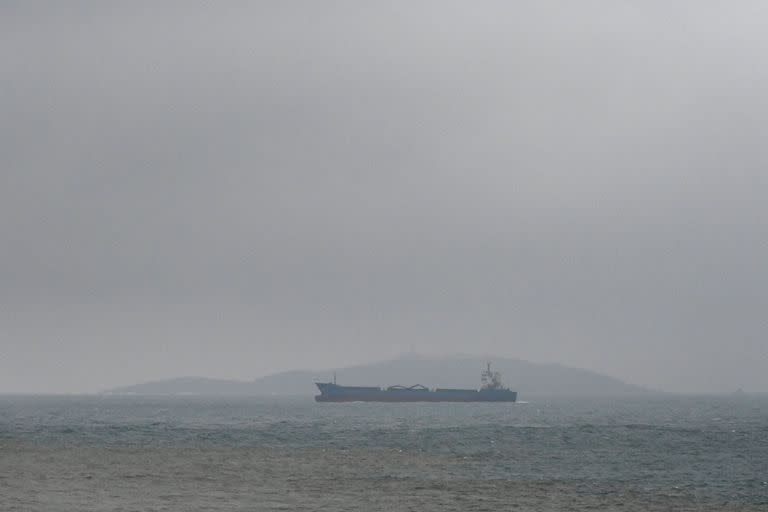 Un carguero pasa junto a una isla del estrecho de Taiwán, visto desde la isla de Pingtan, el punto más cercano a Taiwán, en la provincia china de Fujian, al sureste del país, el 6 de abril de 2023.