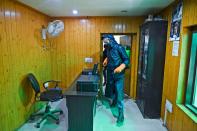 Municipal workers spray disinfectant in a local newspaper's office amid concerns over the spread of the COVID-19 novel coronavirus in Srinagar.