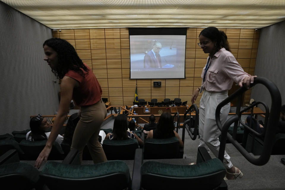 Estudiantes de derecho observan una transmisión en vivo de una sesión llevada por jueces en un área distinta de la Corte Suprema en Brasilia, Brasil, el miércoles 20 de marzo de 2024. (AP Foto/Eraldo Peres)