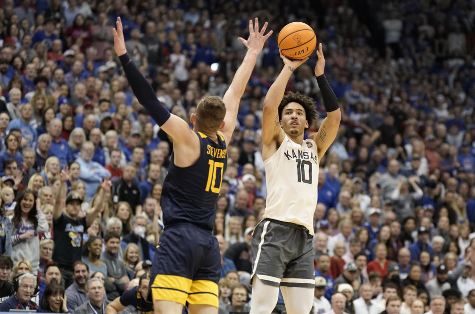 Kansas forward Jalen Wilson (10) puts up a three against West Virginia guard Erik Stevenson (10) during the first half of an NCAA college basketball game on Saturday, Feb. 25, 2023, at Allen Fieldhouse in Lawrence, Kan. (AP Photo/Nick Krug)