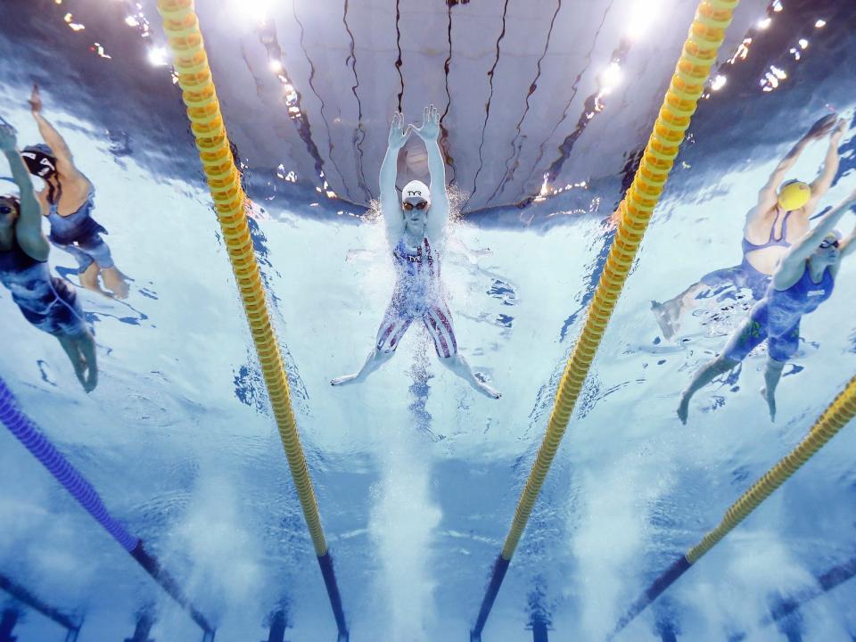 An underwater shot shows the women's 100-meter breaststroke.